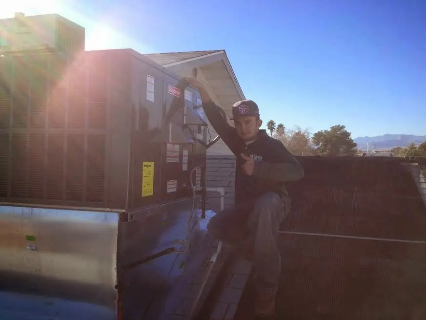 HVAC technician performing AC Tune-Up on a rooftop unit in Kathleen